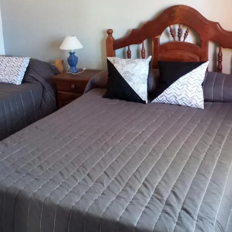 Dormitorio con cama matrimonial y respaldo de madera