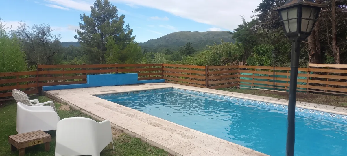 Pileta con reposeras y las sierras de fondo