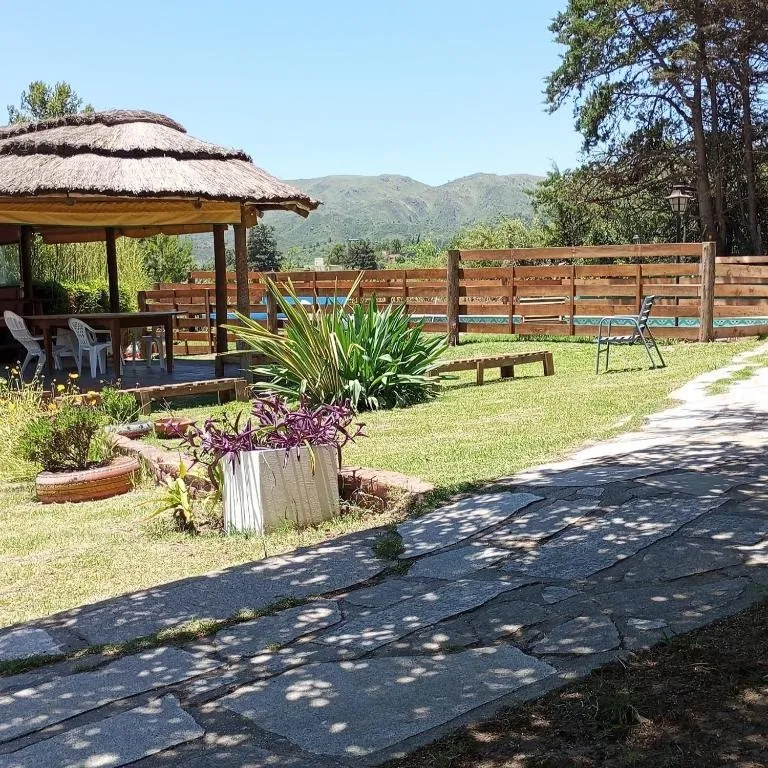 Quincho de paja en el jardín con vista al cerro